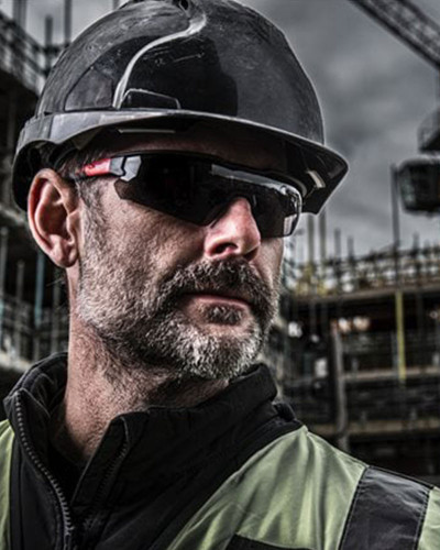 Lunettes de sécurité fumées avec traitement anti-buée et anti-rayure. Vision claire même en conditions difficiles.